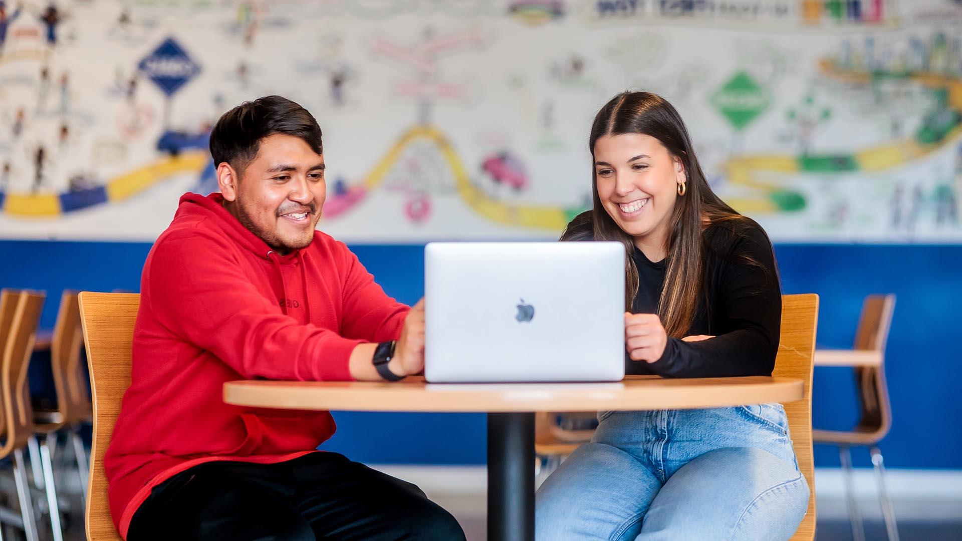 密歇根州立大学丹佛 student Maria Dos Santos Oliveira helps Alejandro Reyes complete his class schedule and finalize his transfer to 密歇根州立大学丹佛.